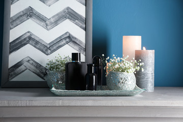 Bottles of perfume, flowers and candles on table