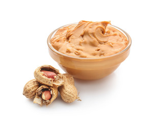 Bowl with tasty peanut butter on white background