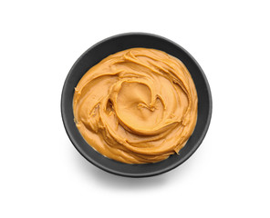 Bowl with tasty peanut butter on white background