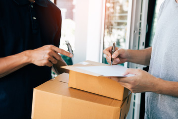 Delivery employee transport parcels pointing to documents for customers to receive products.