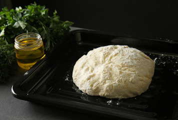 Baking sheet with fresh dough for bread on table