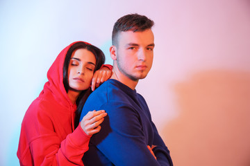 Obraz premium Toned portrait of stylish young couple on light background