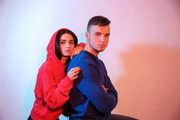 Obraz premium Toned portrait of stylish young couple on light background