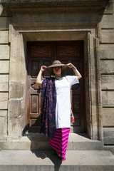 Femme posant devant une porte ancienne de l'hôtel de Sully à Paris