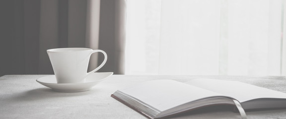 cup of coffee on a table near a window in Scandinavian style minimalism in gray scale with copy space