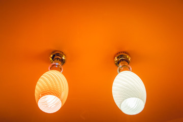 Two lamps on a light brown background.