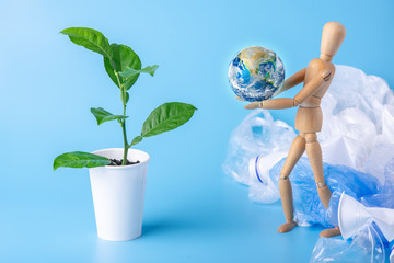 Wooden toy carry the planet to green plant to save the earth from garbage and plastic. Elements furnished by NASA