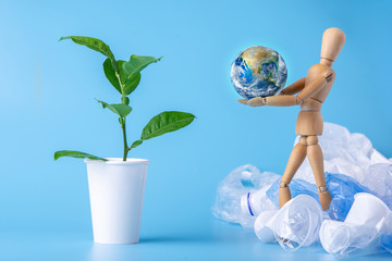 Wooden toy carry the planet to green plant to save the earth from garbage. Waste recycling. Elements furnished by NASA - Powered by Adobe