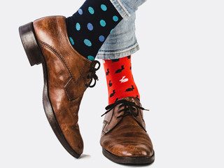 Office Manager in stylish shoes, blue pants and bright, colorful socks on a white, isolated background. Close-up. Lifestyle, fashion, fun, elegance