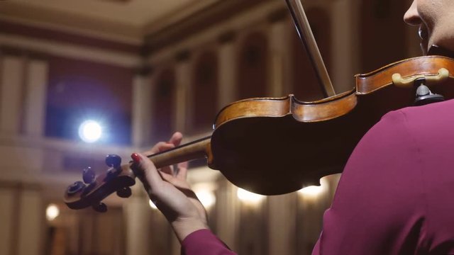 beautiful young girl playing the violin during the concert