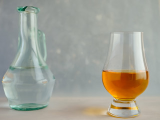 Irish Whiskey Glass And Water Jug on Textured Paper Background