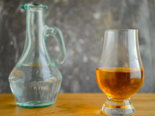 Irish Whiskey Glass And Water Jug on Wood And Slate Textured Background