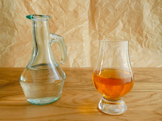 Irish Whiskey Glass and Water Jug on Wood and Paper Background
