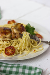 pasta with chicken and tomatoes in a white plate on white background free space for text 