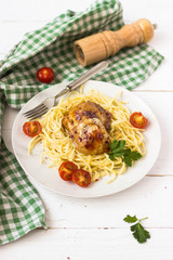 pasta with chicken and tomatoes in a white plate on white background free space for text 