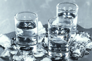 Cold vodka in shot glasses on a black background.