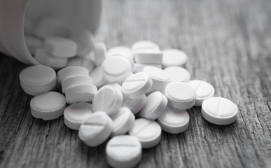 Opioid epidemic, painkillers and drug abuse concept with close up on a bottle, wooden table background copyspace