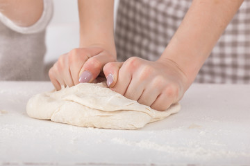 Woman preparing the dough. Closeup still of woman`s hands with daugh and flour. Italian food preparing process.