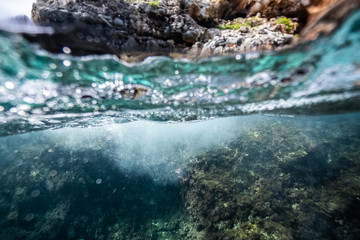 half over half underwater shot on a beautiful bay in Palma de Mallorca, Coast line water line macro shot, underwater photography with a dome port