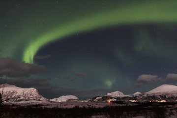 Aurora. Northern lights in Norway. A flash of light in the night sky. Stars in the sky at night. Northern lights and clouds. Winter and snow. Landscape