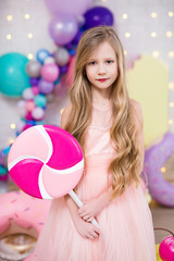 Naklejka premium portrait of cute little girl with big lollipop