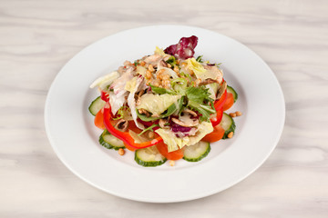 Vegetable salad with corn and mushrooms on a white plate on the table.