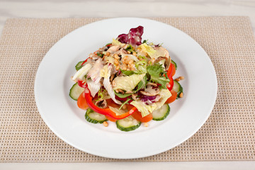 Vegetable salad with corn and mushrooms on a white plate on the table.