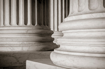 Abstract close-up of the neoclassical white marble fluted columns at the entrance to the US Supreme...