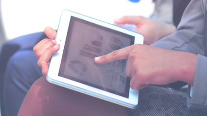 Pressing the thumb to the plate with increasing sales graphs and diagrams. In the background, team work