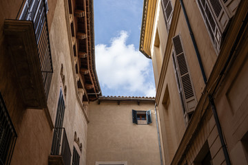 Fototapeta na wymiar in the streets of palma de Mallorca Spain with great sky in the background, great city photography small little street with typical colour