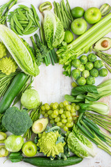 Healthy eating vegan produce. Green vegetables fruits frame on white table broccoli sprouts peas avocado courgette beans bok choy celery apple grapes, top view, copy space, selective focus