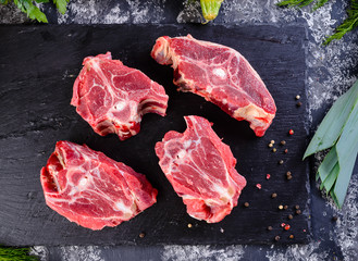Raw fresh meat lamb mutton saddle with herbs and spices on stone slate plate
