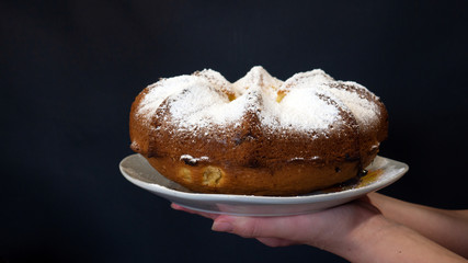 Cupcake with white powder in the hands of a girl