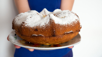 Cupcake with white powder in the hands of a girl