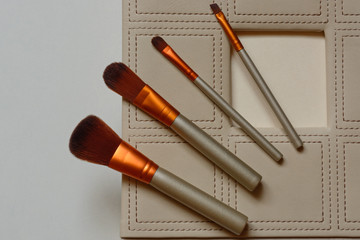 Fototapeta premium Basic makeup brushes on beige background. Set of professional cosmetic brushe. Top view point, flat lay. Copy space