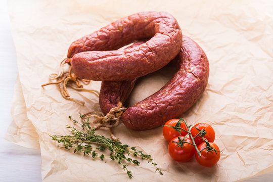 Food, national cuisine and delicious concept - Close up of traditional Kazakh horse meat sausage with tomato and cumin