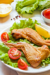 Smoked chicken wings with fresh lettuce tomato and lemon