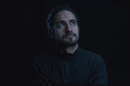 portrait of man meditating in shadows low key
