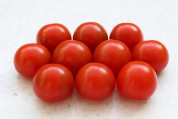 Cherry red tomatoes stack isolated on table.
