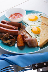 Full english breakfast: fried eggs, bacon and beans