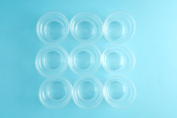group of white disposable plastic cups on blue baskground. Flat lay.