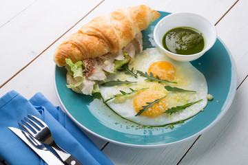 Fried eggs with croissant served for breakfast