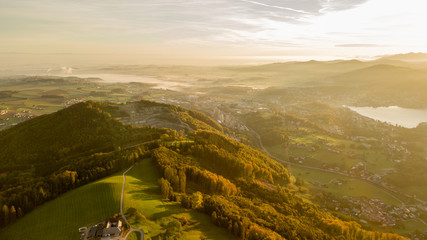fog overt a city in the beautiful heart of austria with a great hill in the foreground, great sunrise in austria