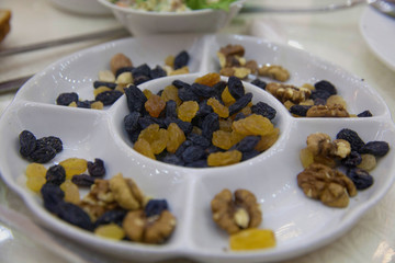 Close up shot of assortment of nuts in basket . Walnuts, hazelnuts, yellow and black raisins 