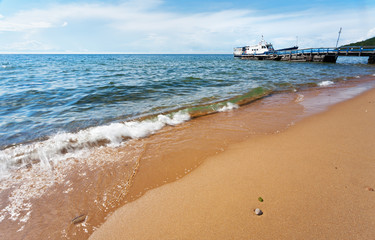 Baikal Lake in summer. Old wooden pier for ships near the Khakusy village, wich is famous for hot mineral springs and many kilometers of sandy beaches
