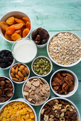 various cereals, nuts and dried fruits on wooden surface