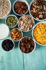various cereals, nuts and dried fruits on wooden surface