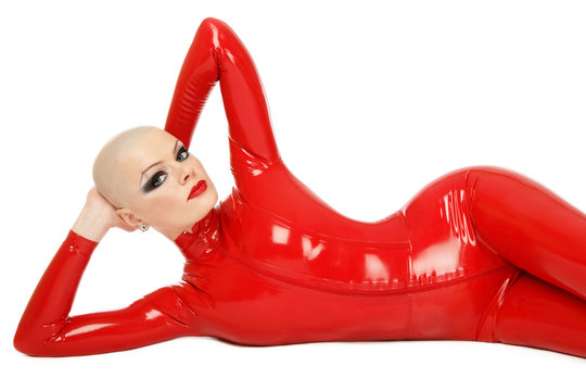 Skinhead sexy woman in red latex catsuit over white background