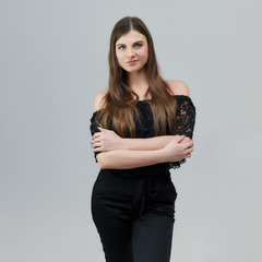 Concept portrait of a pretty beautiful brunette girl talking on a gray background in the studio standing