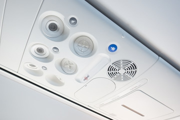 Cabin inside the plane, air condition, lights and signs panel above the seat